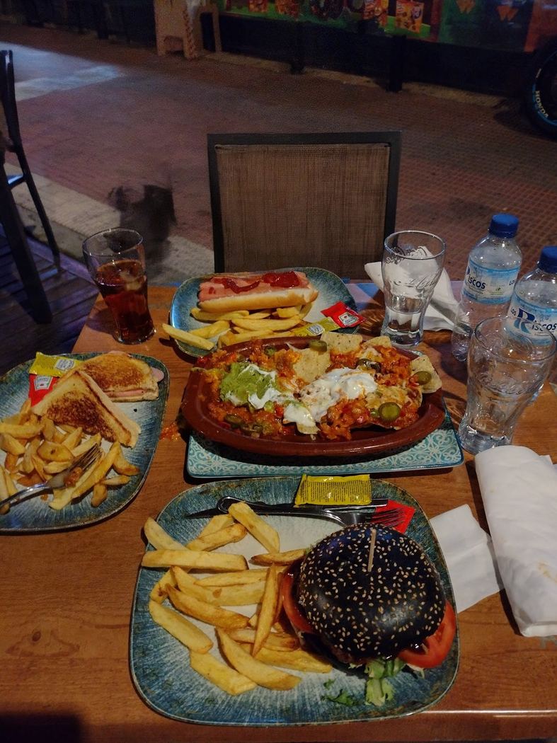 Selección de platos para compartir en el Bar Route 54, como nachos, sándwiches y perritos calientes.